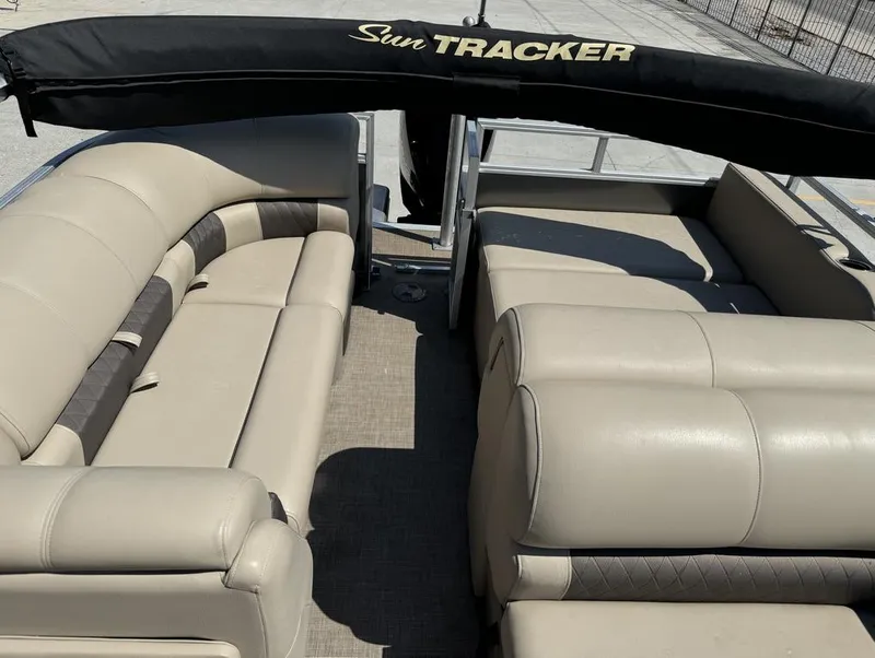 Slide: The Image of 2023 Sun Tracker Party Barge 22 DLX interior with beige seating and black canopy. - 15