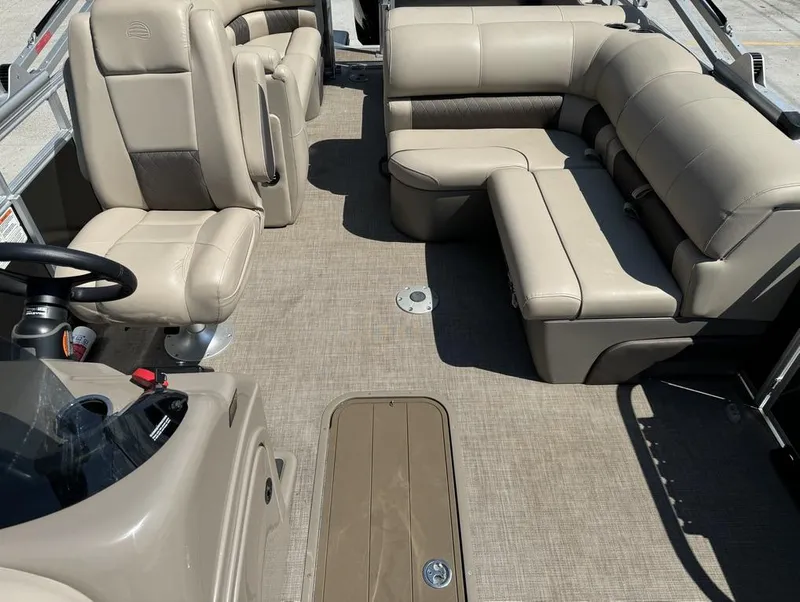 Slide: The Image of 2023 Sun Tracker Party Barge 22 DLX interior with beige seating and steering console. - 3