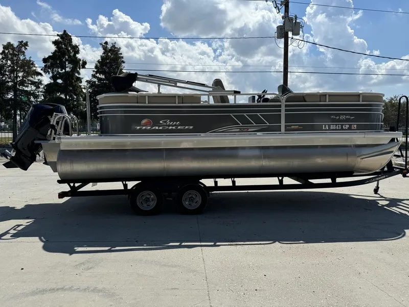 Slide: The Image of 2023 Sun Tracker Party Barge 22 DLX pontoon boat on trailer, parked outdoors. - 4