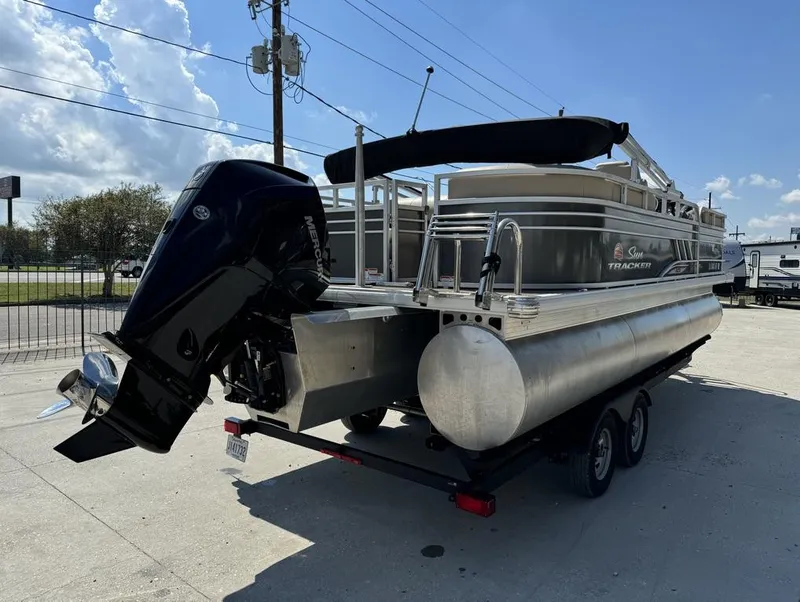 Slide: The Image of 2023 Sun Tracker Party Barge 22 DLX pontoon boat on trailer, outdoor setting. - 5