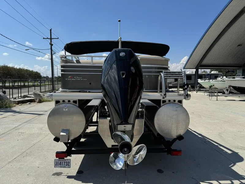 Slide: The Image of 2023 Sun Tracker Party Barge 22 DLX pontoon boat with outboard motor, parked outdoors. - 6