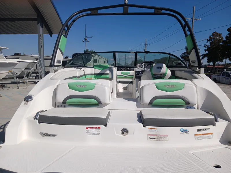 Slide: The Image of 2016 Chaparral 203 Vortex boat with green and white interior, parked outdoors. - 8