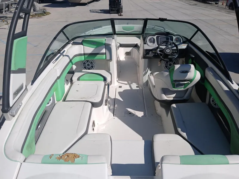 Slide: The Image of 2016 Chaparral 203 Vortex boat interior with green and white seating, steering wheel, and dashboard. - 9