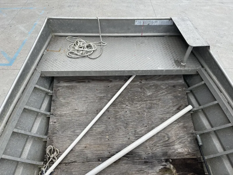 Slide: The Image of Interior of a 1991 Custom 18ft boat with wooden floor and coiled rope. - 14