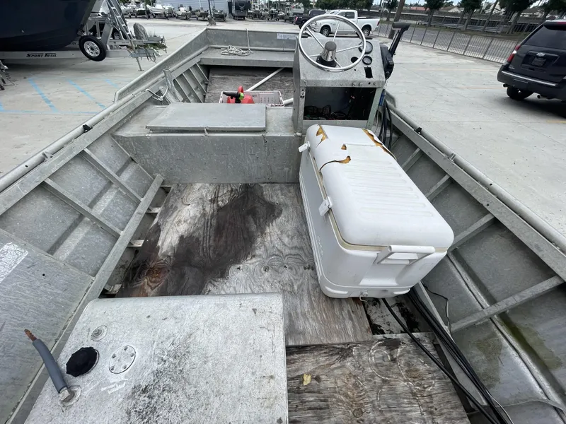 Slide: The Image of Interior of a 1991 Custom 18ft boat with steering console and cooler. - 16