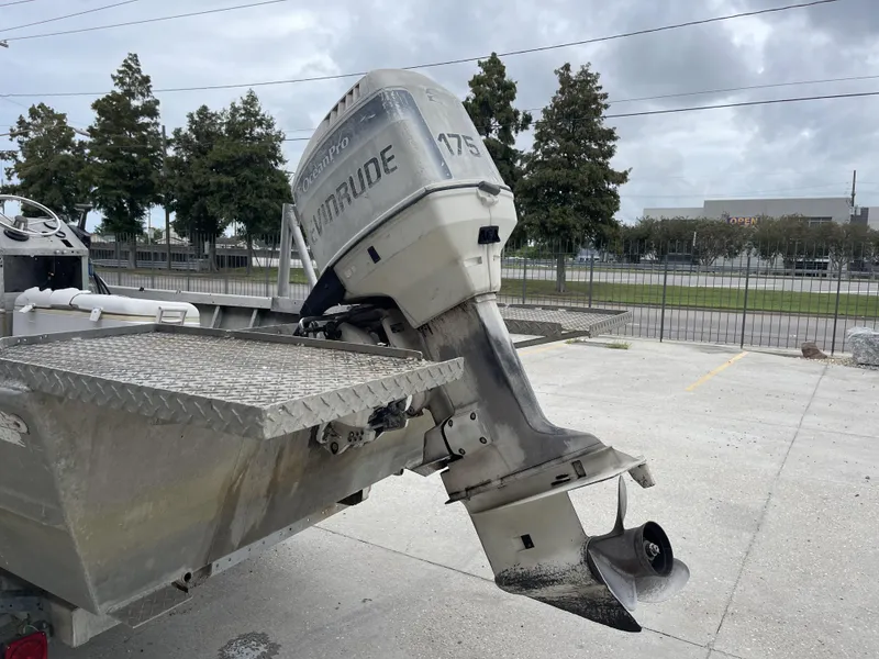 Slide: The Image of 1991 Custom 18ft boat with Evinrude 175 outboard motor, parked outdoors. - 17