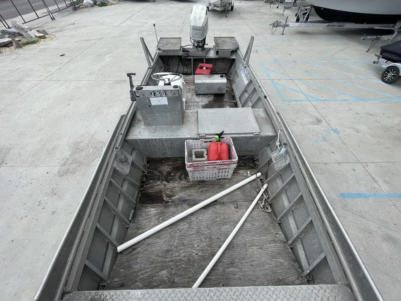 Slide: The Image of 1991 Custom 18ft aluminum boat with outboard motor, docked on concrete surface. - 4