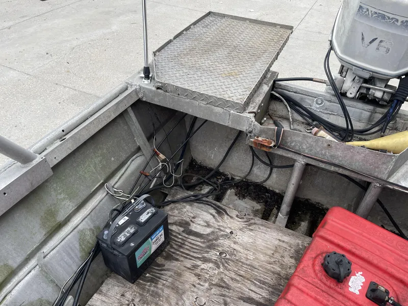 Slide: The Image of Interior of a 1991 Custom 18ft boat showing battery, wiring, and V6 engine. - 7