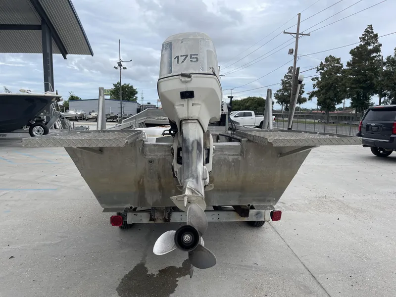 Slide: The Image of Custom 18ft boat from 1991 with outboard motor, parked on concrete. - 9