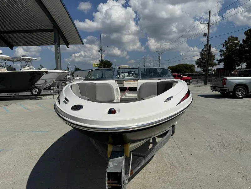 Slide: The Image of 2011 Sea Ray 185 Sport boat on trailer, parked outdoors under a cloudy sky. - 11