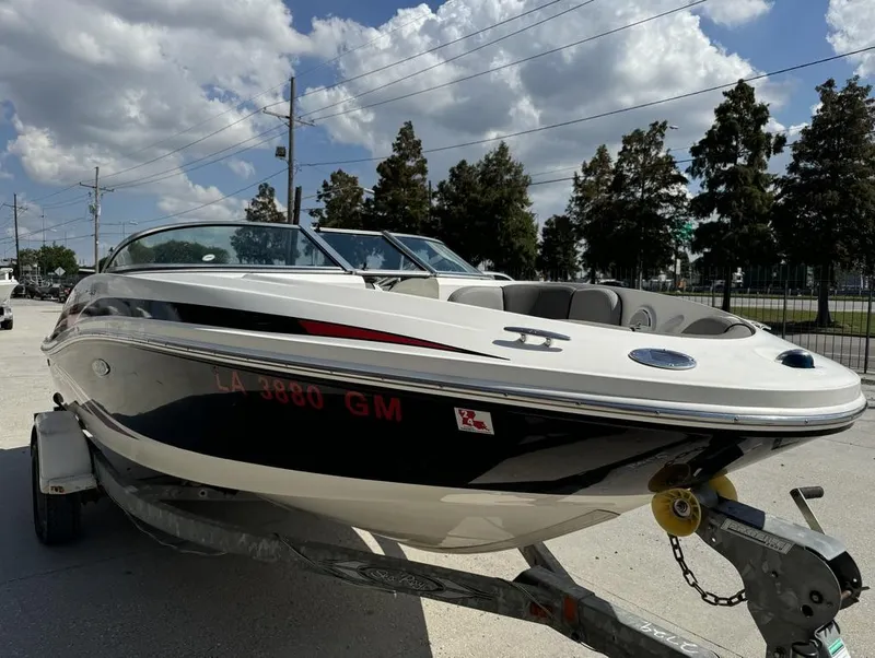 Slide: The Image of 2011 Sea Ray 185 Sport boat on trailer under a partly cloudy sky. - 12