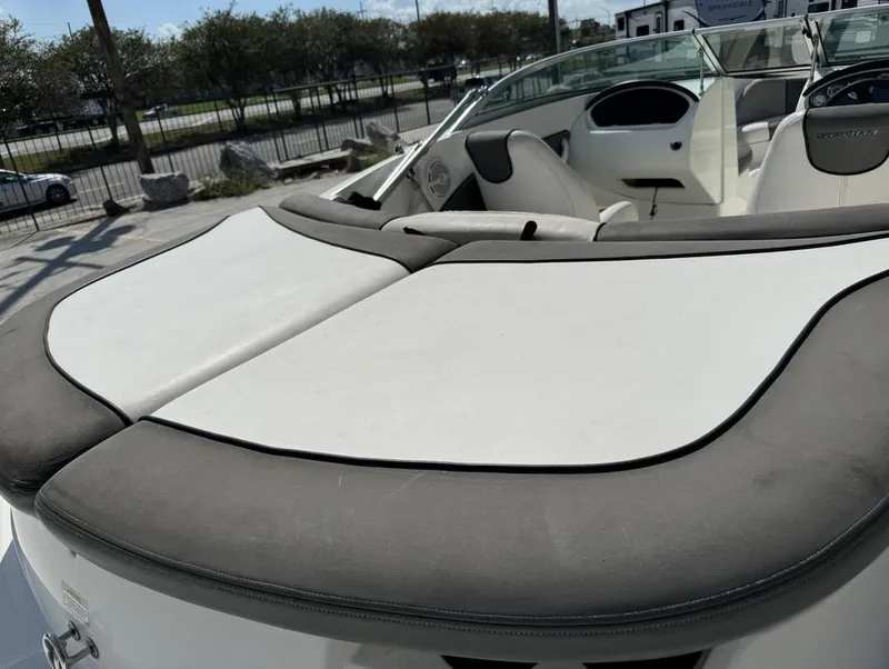 Slide: The Image of 2011 Sea Ray 185 Sport boat interior with cushioned seating and dashboard view. - 13