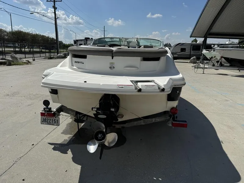 Slide: The Image of 2011 Sea Ray 185 Sport boat, rear view, parked outdoors under clear sky. - 3