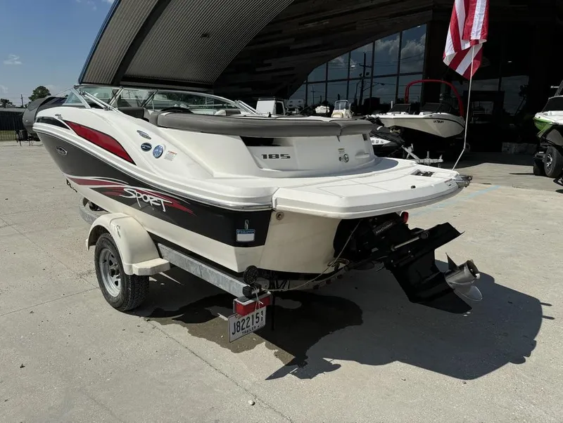 Slide: The Image of 2011 Sea Ray 185 Sport boat on trailer, parked outdoors near a building. - 4
