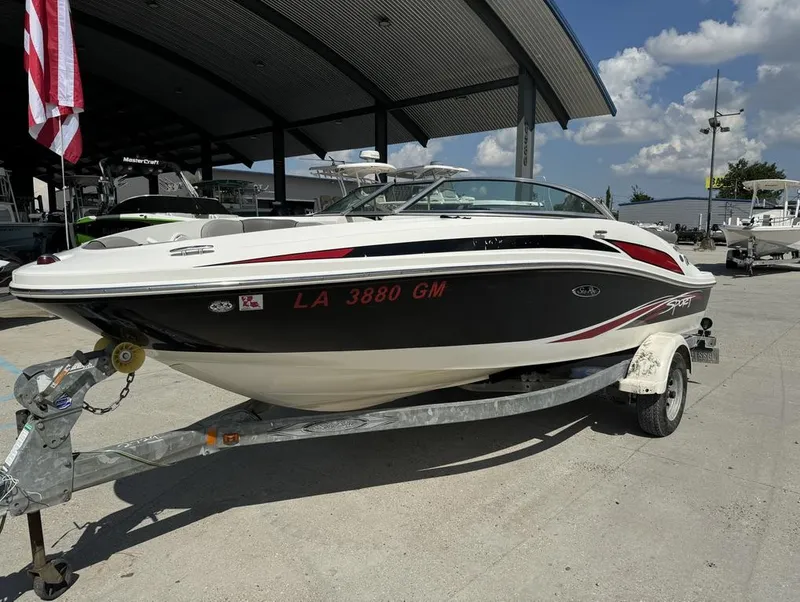 Slide: The Image of 2011 Sea Ray 185 Sport boat on trailer, parked outdoors under a clear sky. - 5