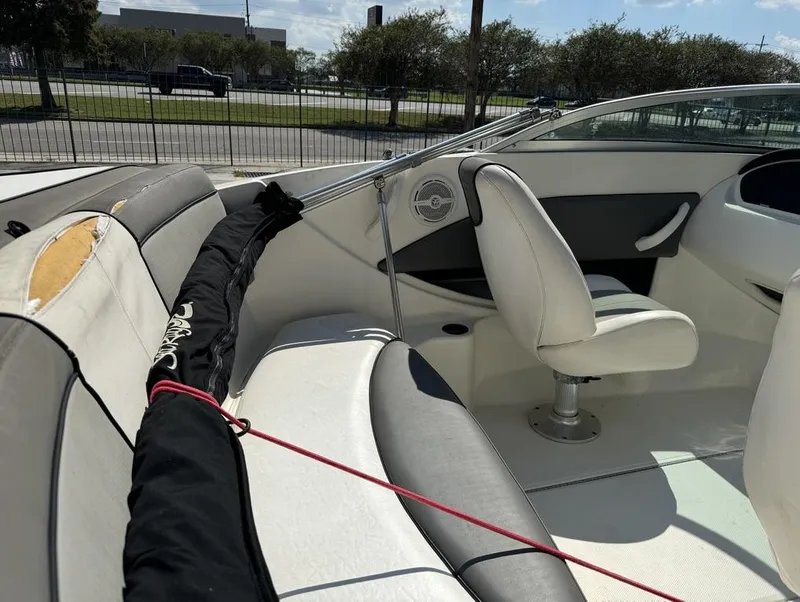 Slide: The Image of Interior of a 2011 Sea Ray 185 Sport boat with white seating and a black cover. - 8