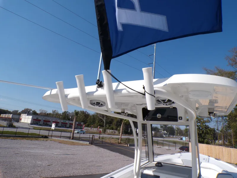 Slide: The Image of 2024 Parker 2600 Center Console boat with rod holders and flag, parked outdoors. - 20