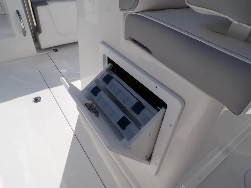Slide: The Image of 2024 Parker 2600 Center Console boat storage compartment with open tackle box. - 22