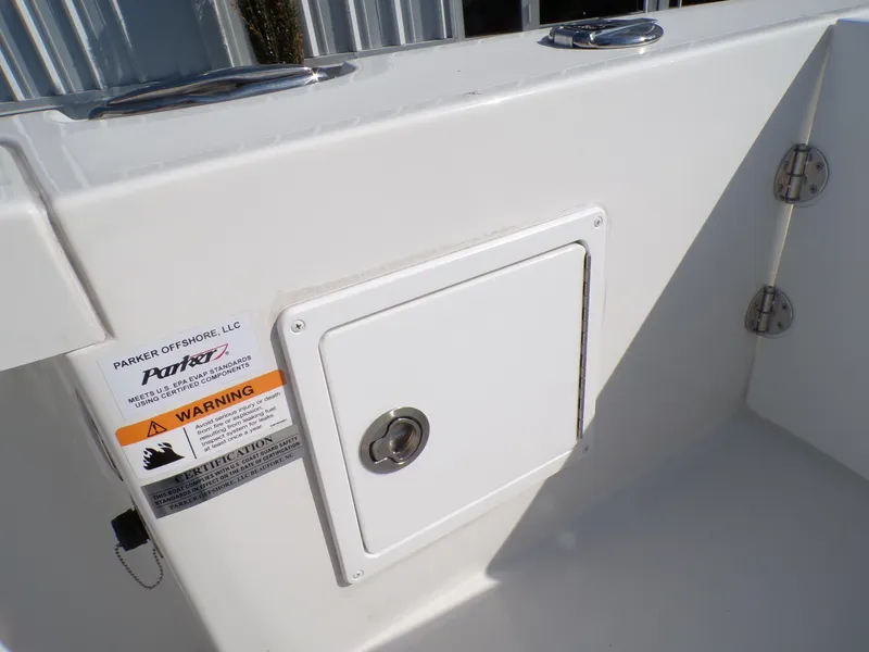Slide: The Image of 2024 Parker 2600 Center Console boat storage compartment with warning label. - 26
