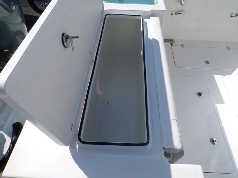 Slide: The Image of 2024 Parker 2600 Center Console boat storage compartment, open lid, white interior. - 30