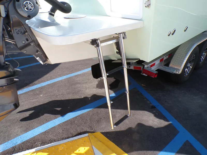 Slide: The Image of 2024 Parker 2600 Center Console boat with a foldable swim ladder on a trailer. - 5