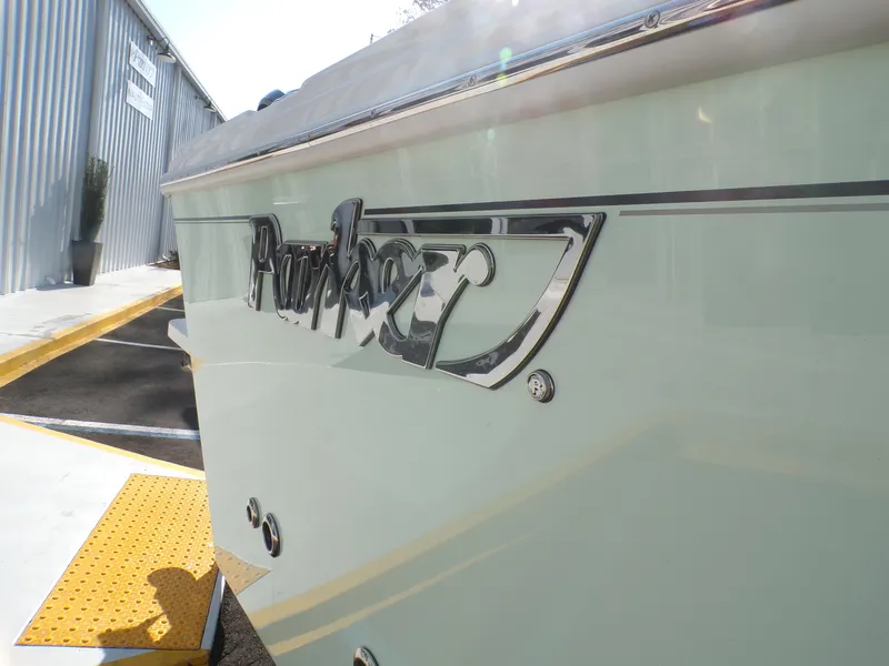 Slide: The Image of 2024 Parker 2600 Center Console boat, side view with logo, near a building. - 8