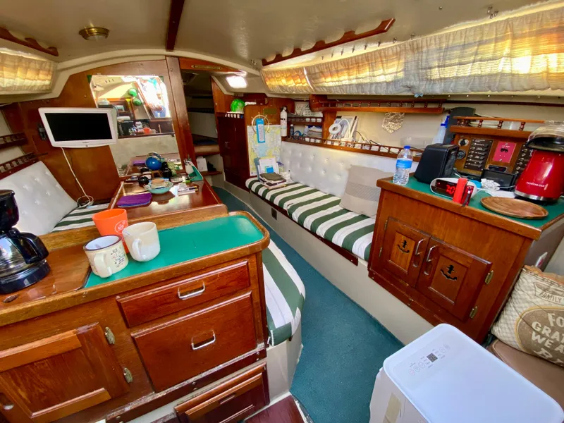 Slide: The Image of Interior of a 1978 Catalina 30 sailboat with cozy seating and kitchen area. - 21