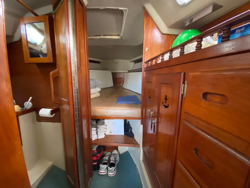 Slide: The Image of Interior of a 1978 Catalina 30 sailboat with wooden cabinetry and cozy sleeping quarters. - 26