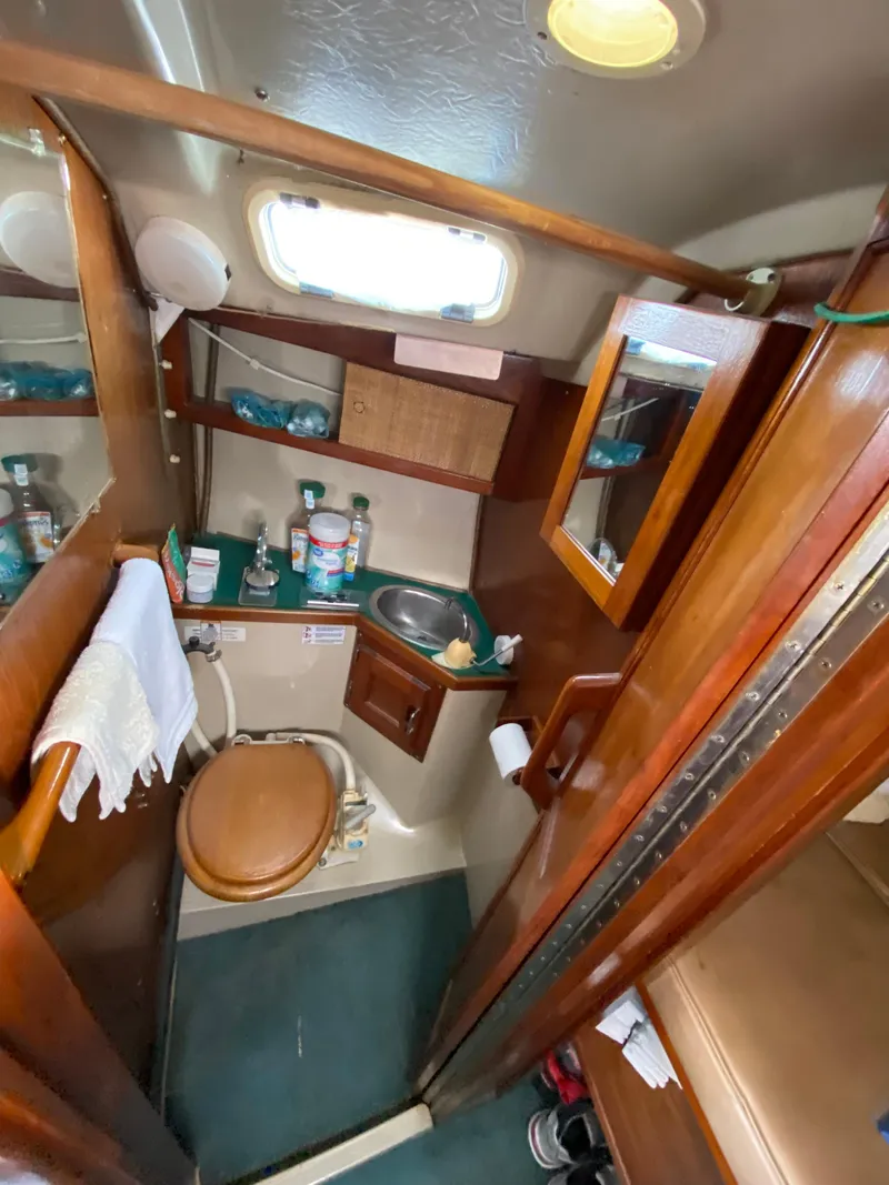 Slide: The Image of 1978 Catalina 30 sailboat bathroom with wooden cabinetry and compact design. - 27