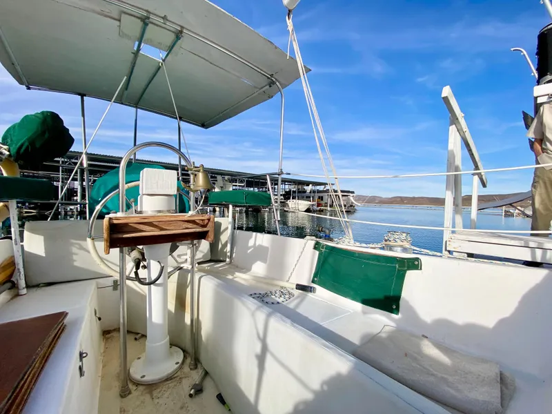 Slide: The Image of 1978 Catalina 30 sailboat cockpit with green accents, docked by calm waters under blue sky. - 29