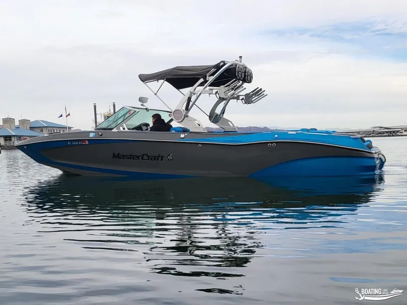 Slide: The Image of 2021 MasterCraft X26 boat on calm water, featuring sleek design and modern amenities. - 10