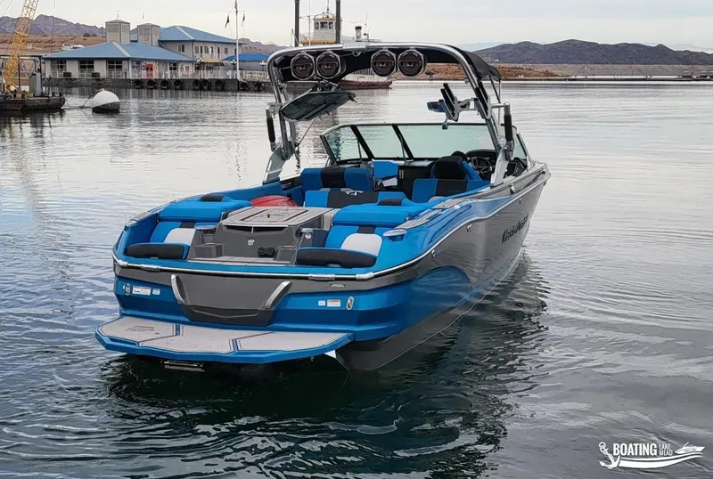 Slide: The Image of 2021 MasterCraft X26 boat on calm water, featuring blue and white design. - 12