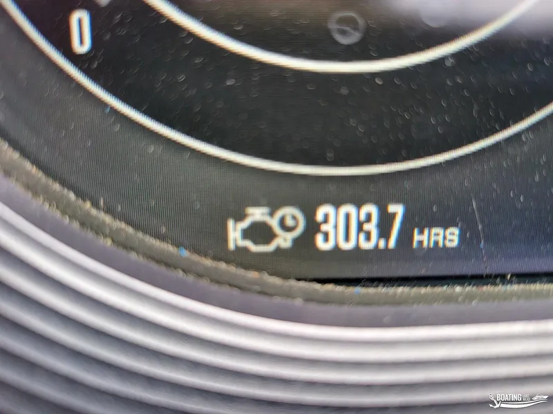 Slide: The Image of Close-up of MasterCraft X26 2021 engine hours display showing 303.7 hours. - 20