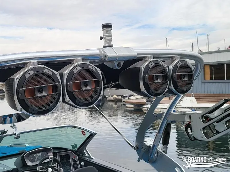 Slide: The Image of 2021 MasterCraft X26 boat with mounted speakers at a marina. - 23