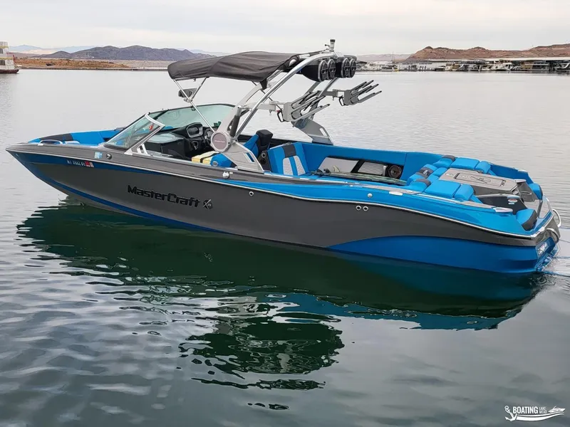 Slide: The Image of 2021 MasterCraft X26 boat with blue and gray design on calm water. - 5