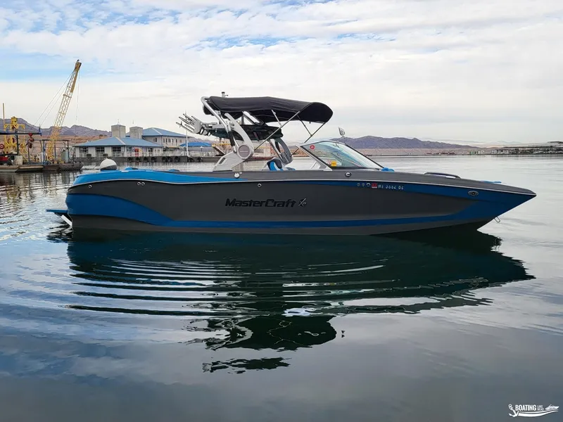 Slide: The Image of 2021 MasterCraft X26 boat on calm water, featuring sleek design and modern amenities. - 6