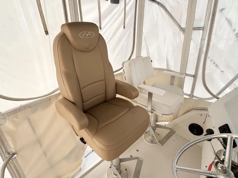 Slide: The Image of Captain's chairs on 1999 Luhrs 360 Convertible boat, featuring tan and white seating. - 10