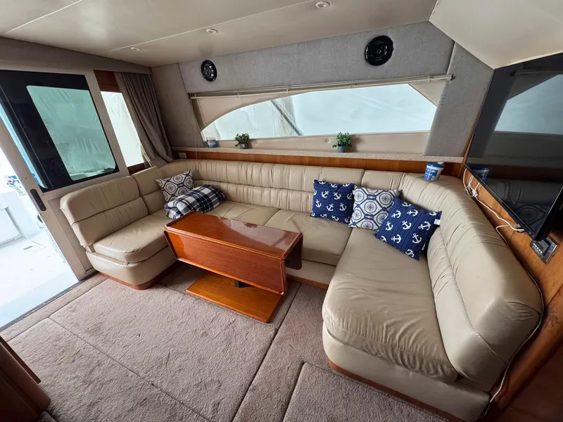 Slide: The Image of 1999 Luhrs 360 Convertible yacht interior with beige leather seating and decorative pillows. - 13