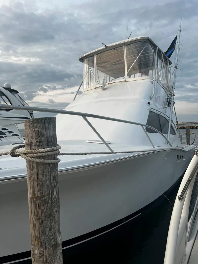 Slide: The Image of 1999 Luhrs 360 Convertible boat docked under cloudy sky. - 6