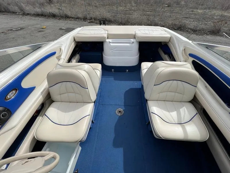 Slide: The Image of 1997 Sea Ray 210 Open Bow boat interior with blue carpet and white seating. - 12