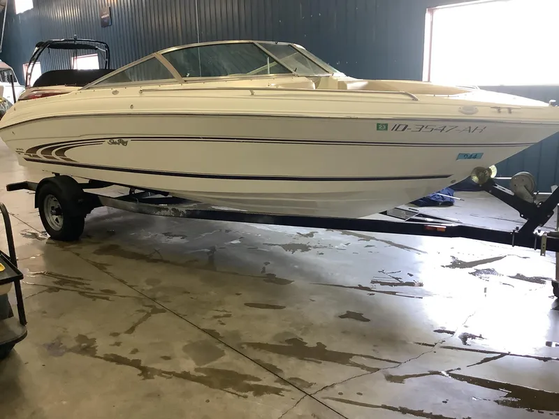 Slide: The Image of 1997 Sea Ray 210 Open Bow boat on trailer in indoor storage. - 3
