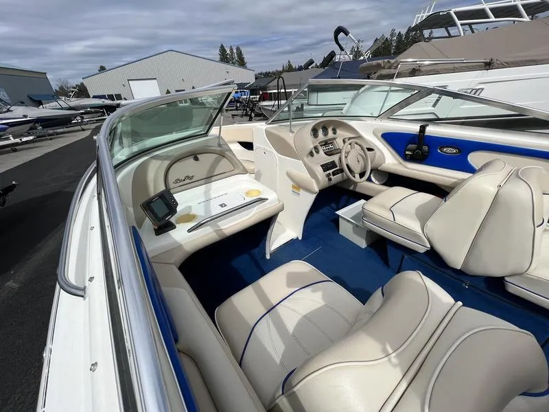 Slide: The Image of 1997 Sea Ray 210 Open Bow boat interior with beige and blue seating. - 8