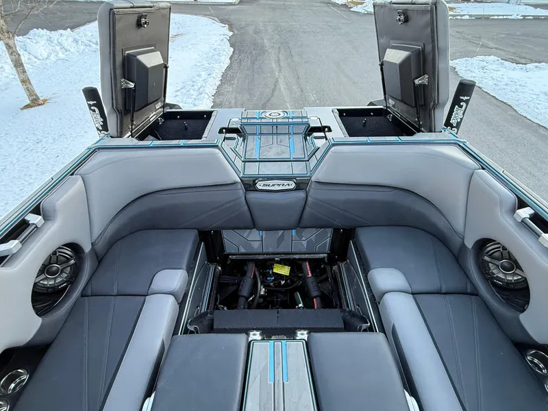 Slide: The Image of 2022 Supra SL boat interior with open storage compartments, gray seating, and speakers. - 20