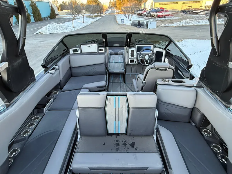 Slide: The Image of 2022 Supra SL boat interior with modern seating and steering wheel, parked in snowy area. - 25