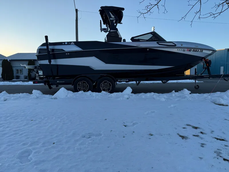 Slide: The Image of 2022 Supra SL boat on trailer, parked on snowy street. - 35