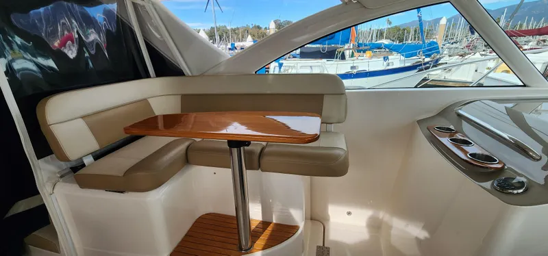Slide: The Image of 2012 Tiara Yachts 3100 Coronet interior with seating and table, docked at marina. - 11