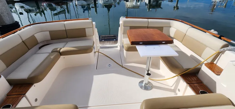 Slide: The Image of 2012 Tiara Yachts 3100 Coronet interior with beige seating and wooden table. - 15
