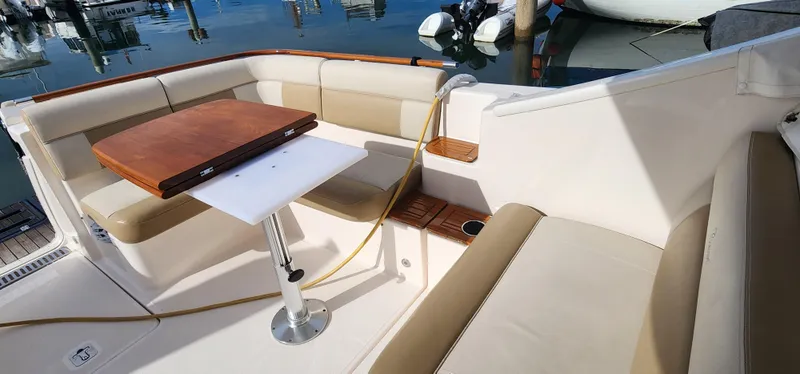 Slide: The Image of 2012 Tiara Yachts 3100 Coronet interior with seating and table, docked at marina. - 17