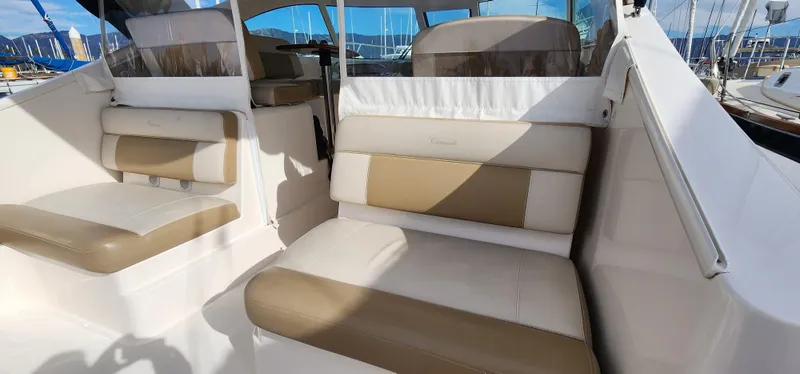 Slide: The Image of 2012 Tiara Yachts 3100 Coronet interior with beige and white seating, docked at marina. - 19