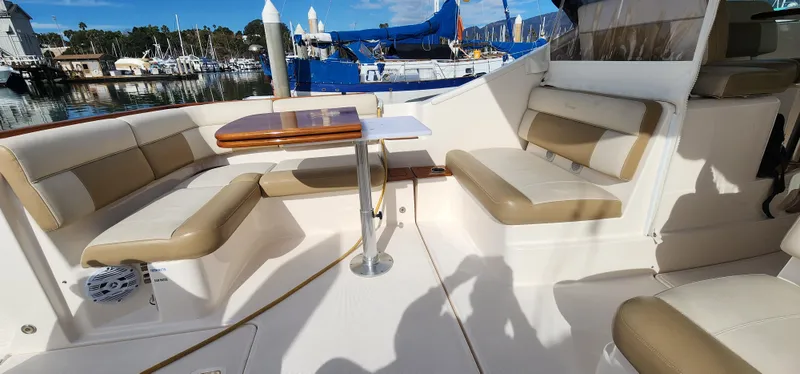 Slide: The Image of 2012 Tiara Yachts 3100 Coronet interior with beige seating and table, docked at marina. - 21